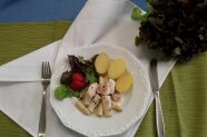 Spargel- und Fleischstücke mit Salzkartoffel und Salatgarnitur auf Teller angerichtet